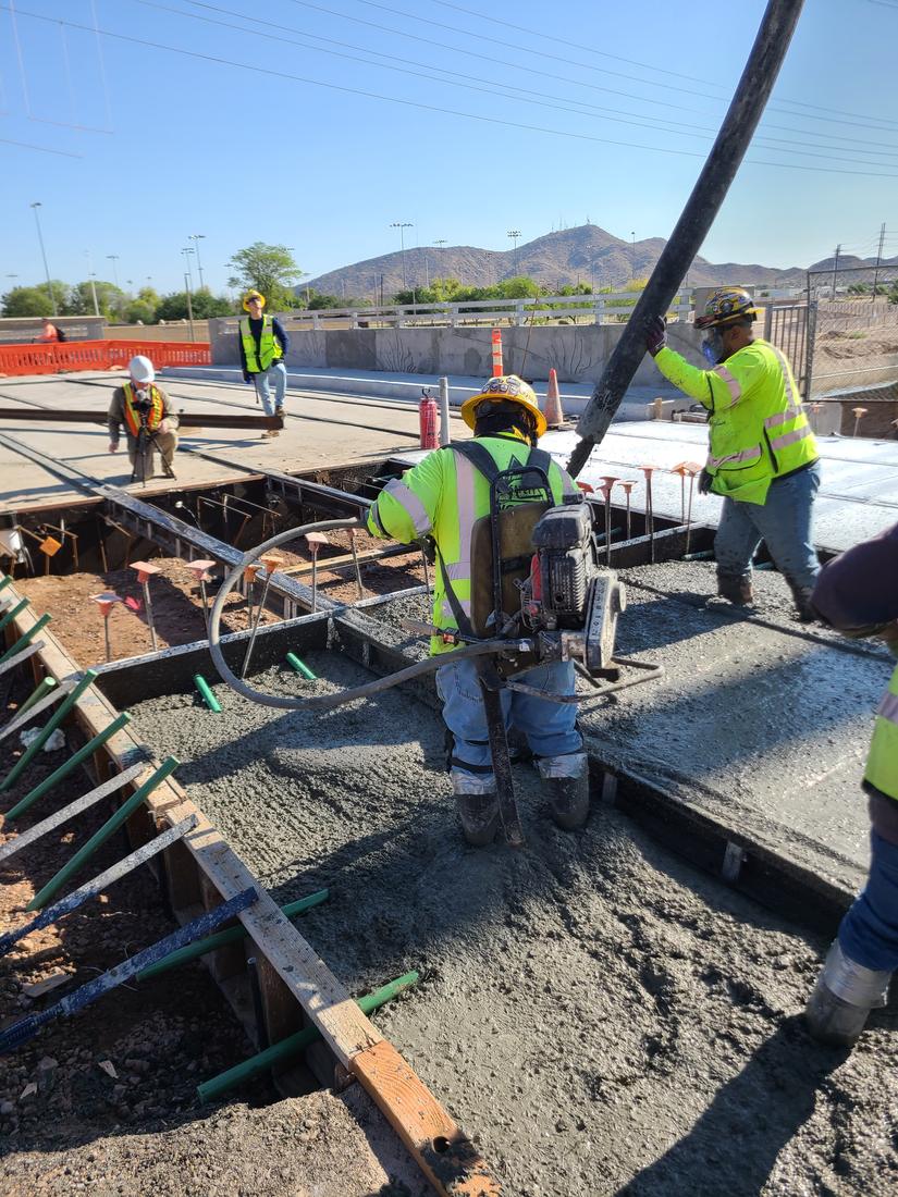 Workers placing the fiber concrete between the rails from a pump hose